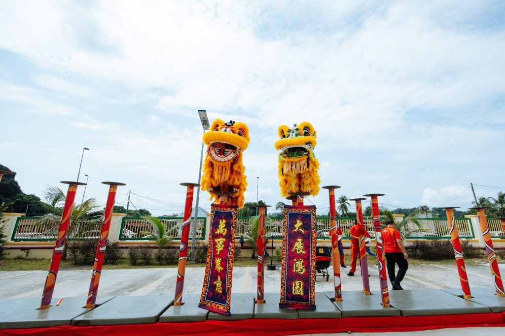 Lion dance performance on poles at a company grand opening ceremony