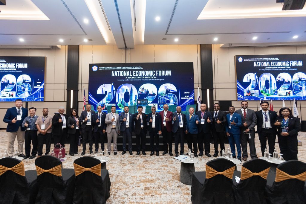Speakers and guests on stage for a group photo at a national economic forum